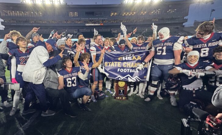 Dakota Ridge players gather around the 4A championship trophy