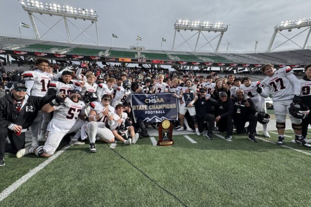 Pomona football gathered around the Class 3A football trophy
