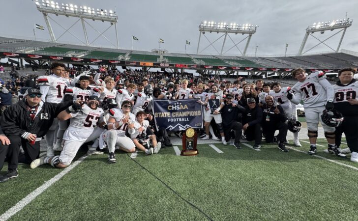 Pomona football gathered around the Class 3A football trophy